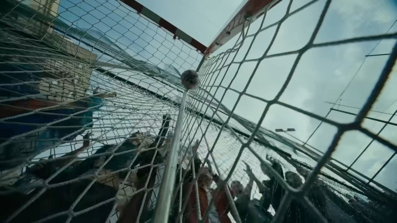 Frame from the adidas Football Anthem Film: looking up through a goal net at players celebrating