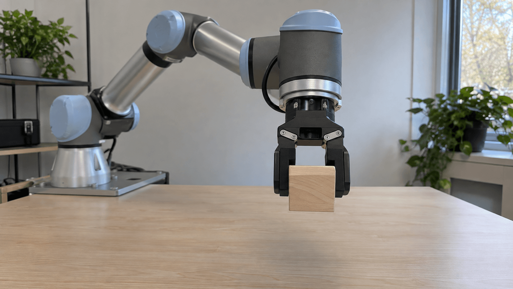 Participant’s eye-level view of a collaborative robot extending a wooden cube across a table toward them